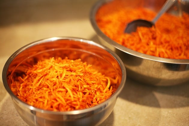 Dividing shredded carrots into portions. 