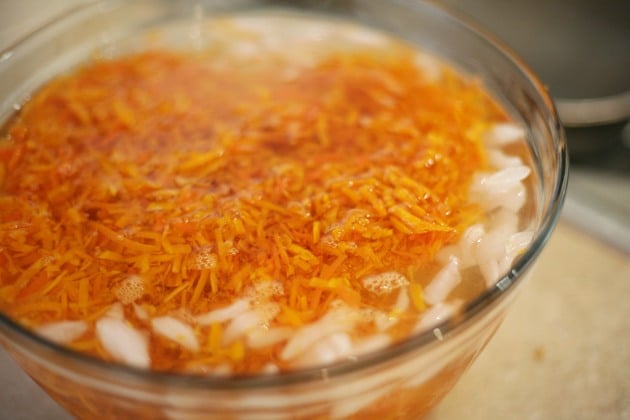 Adding shredded carrots to ice bath. 