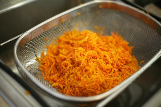 Draining shredded carrots.