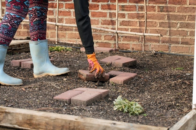 Removing the bricks from the garden bed.