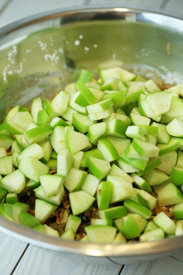 Adding apples to the cake batter. 