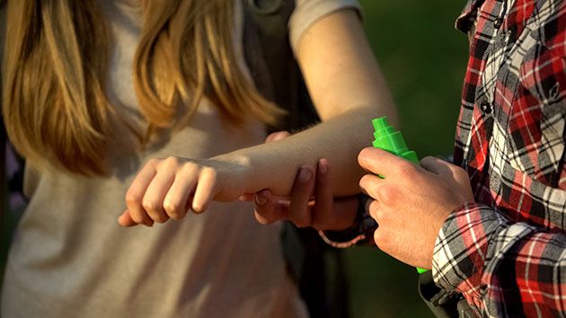 Spraying arms against chiggers. 