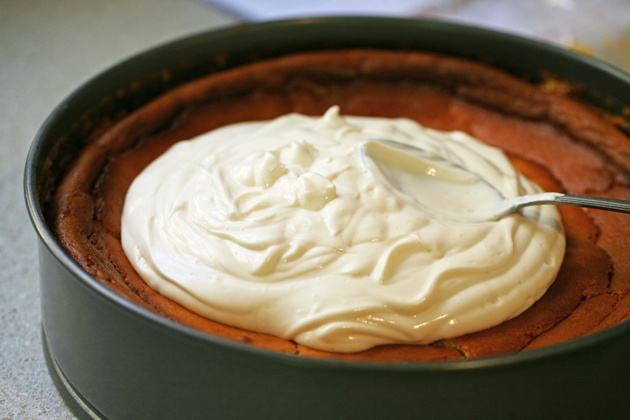 Adding the topping on the pumpkin cheesecake.