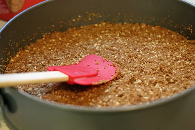 Adding crust ingredients to the cake pan.