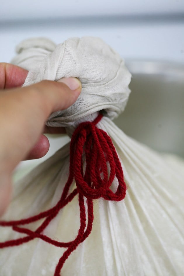 Tying the cheesecloth.  