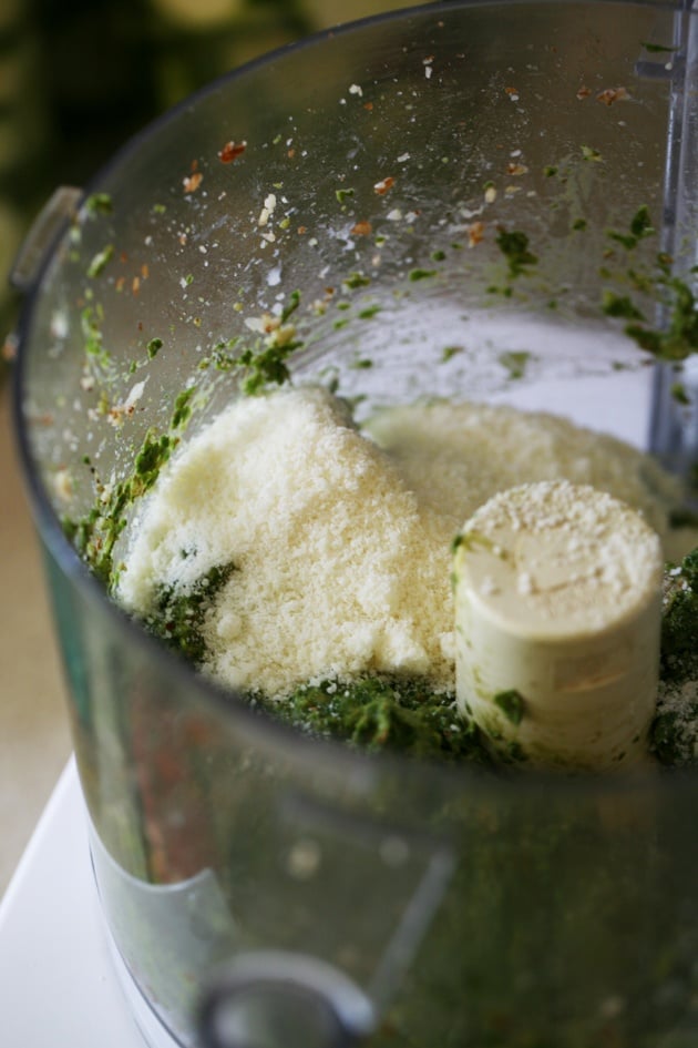 Adding parmesan cheese to pesto