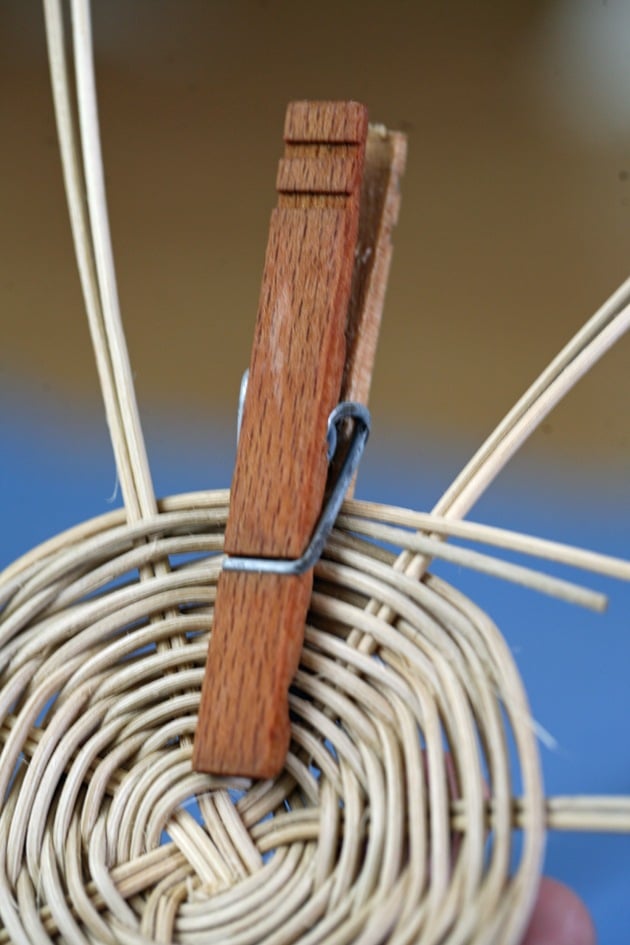 Using clothespins to hold a weaved basket.