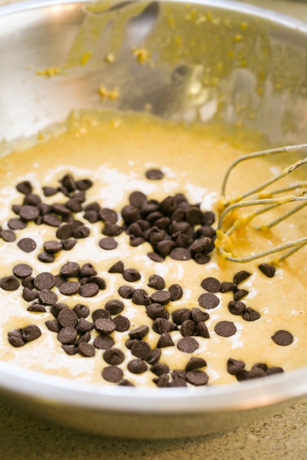 Adding chocolate chips to pumpkin bread batter.