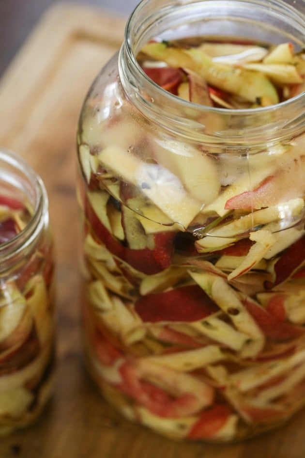 Adding water to the jar of apple scraps.