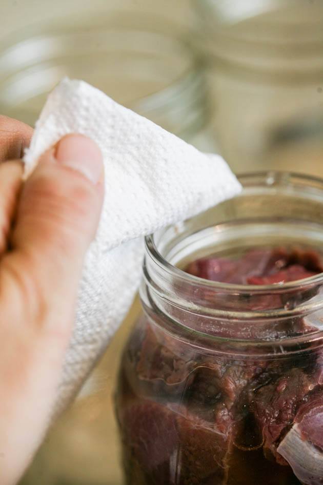 Cleaning the rim of the jar with a paper towel