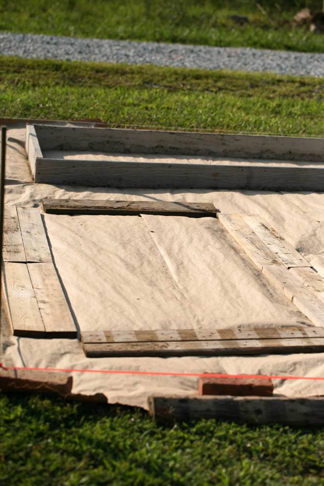 Laying the pallet wood before building the raised bed. 