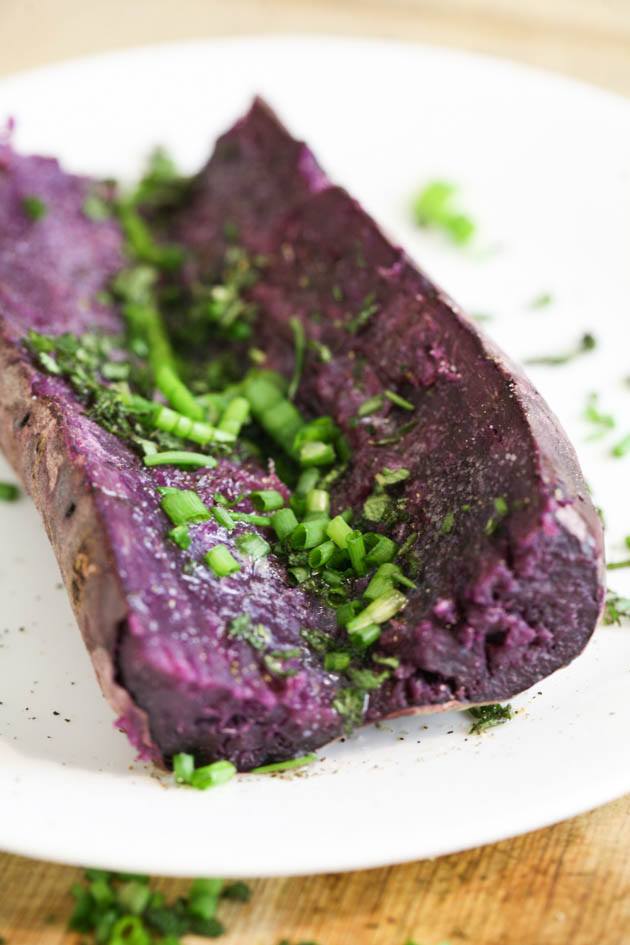 Seasoning the baked purple sweet potato with the greens and butter.