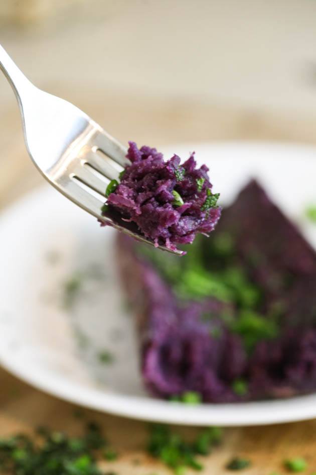 Baked purple sweet potato on a fork.
