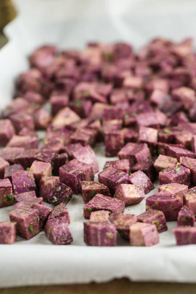 Placing diced purple sweet potatoes on a baking sheet in one layer. 