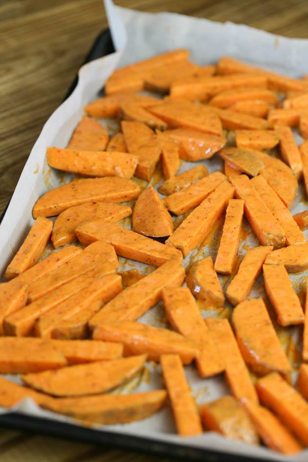 Spreading the sweet potato fries on a baking sheet. 