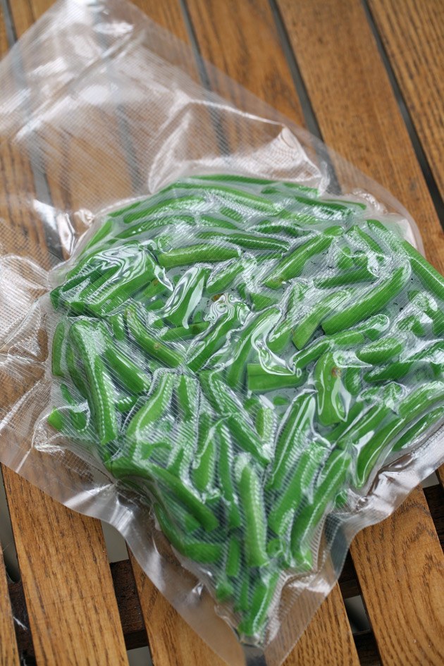 Packing green beans in a vacuum sealer.