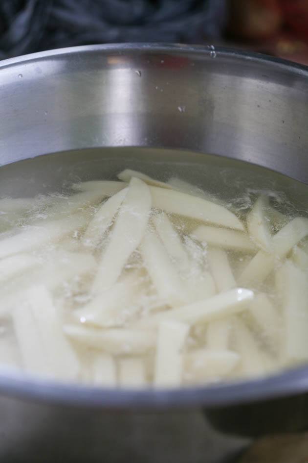 Potatoes in a bowl of water before blanching