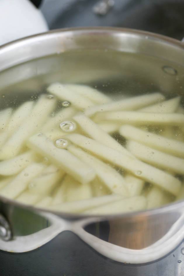 Blanching potatoes in a pot of boiling water