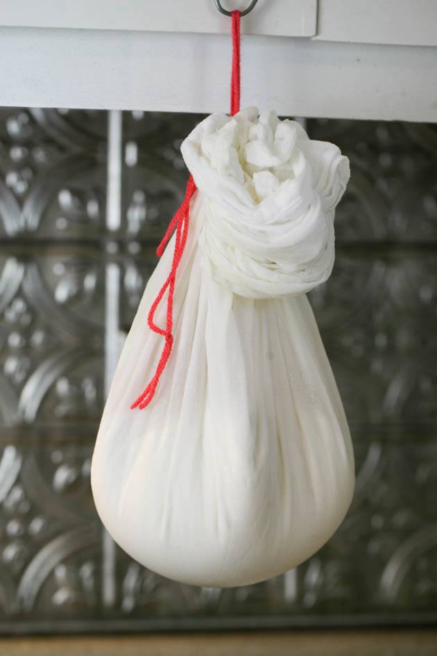 Hanging the curds to drain.