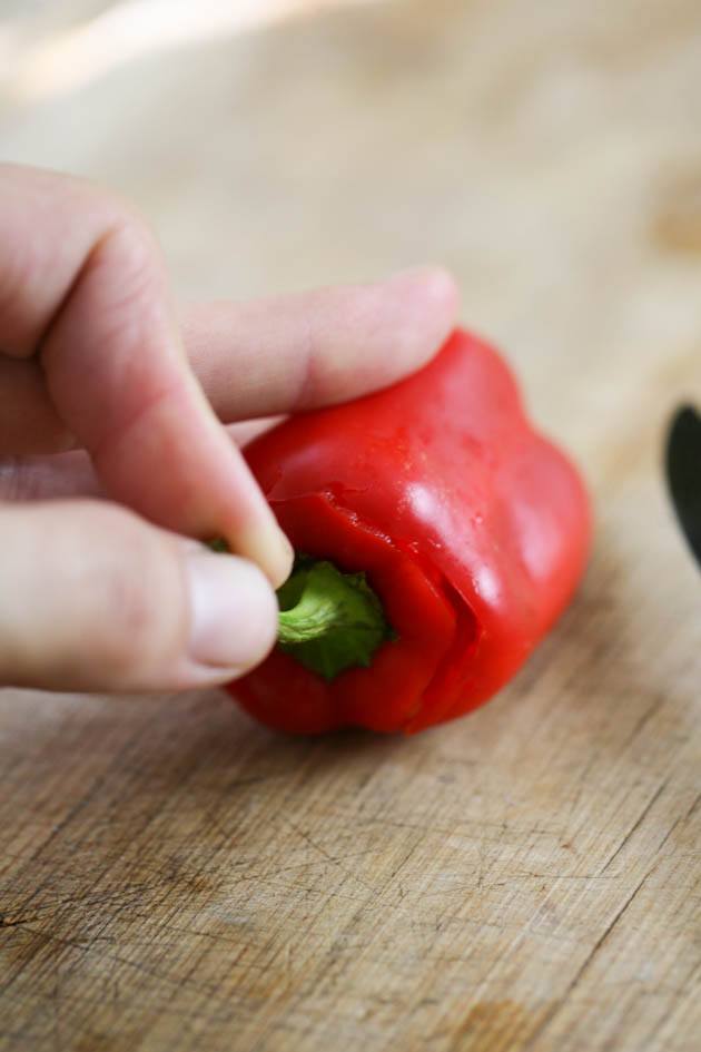 Removing the stem of the peppers.