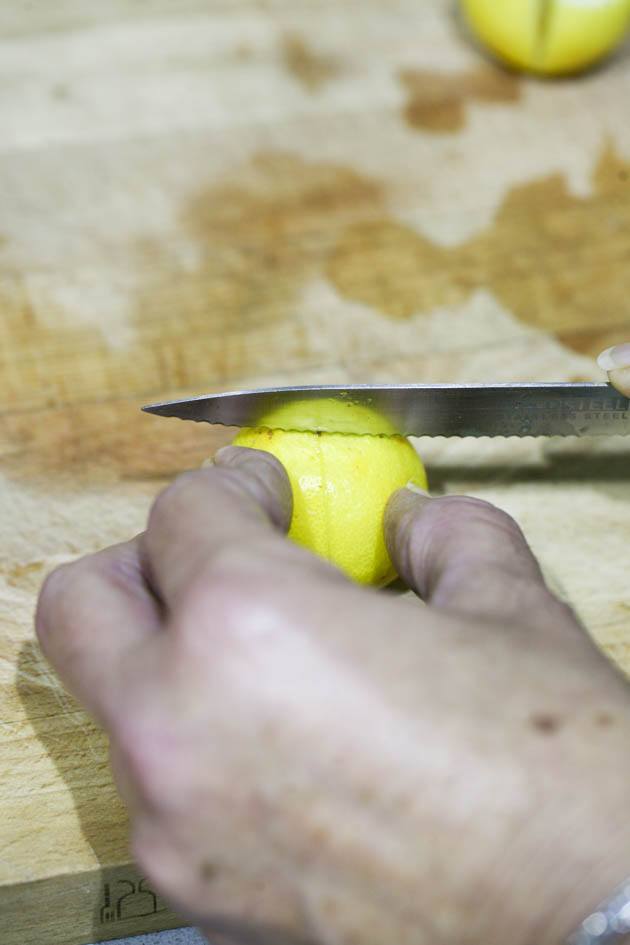 Slicing lemons into quarters.