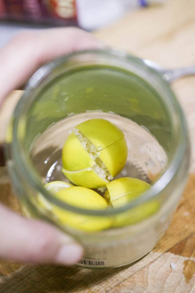 Adding lemons to the jar.