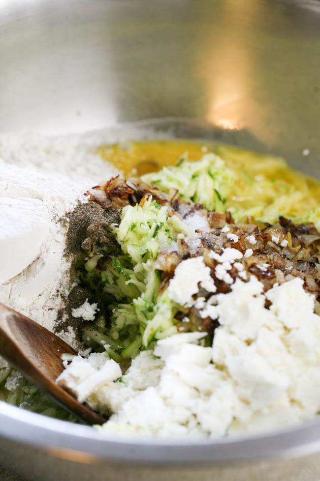 Mixing zucchini casserole ingredients in a large bowl. 