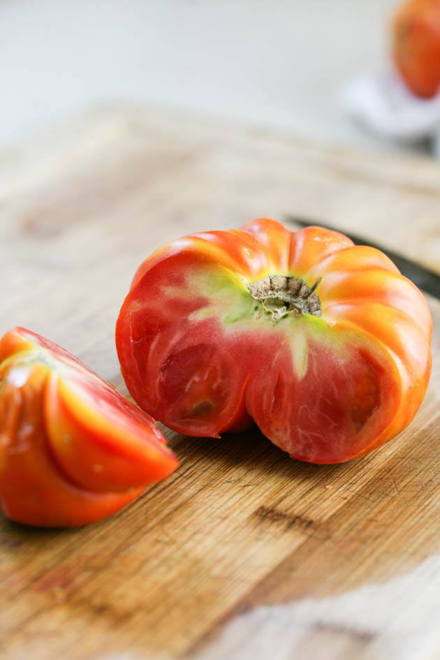 Cutting the damaged part of the tomato.