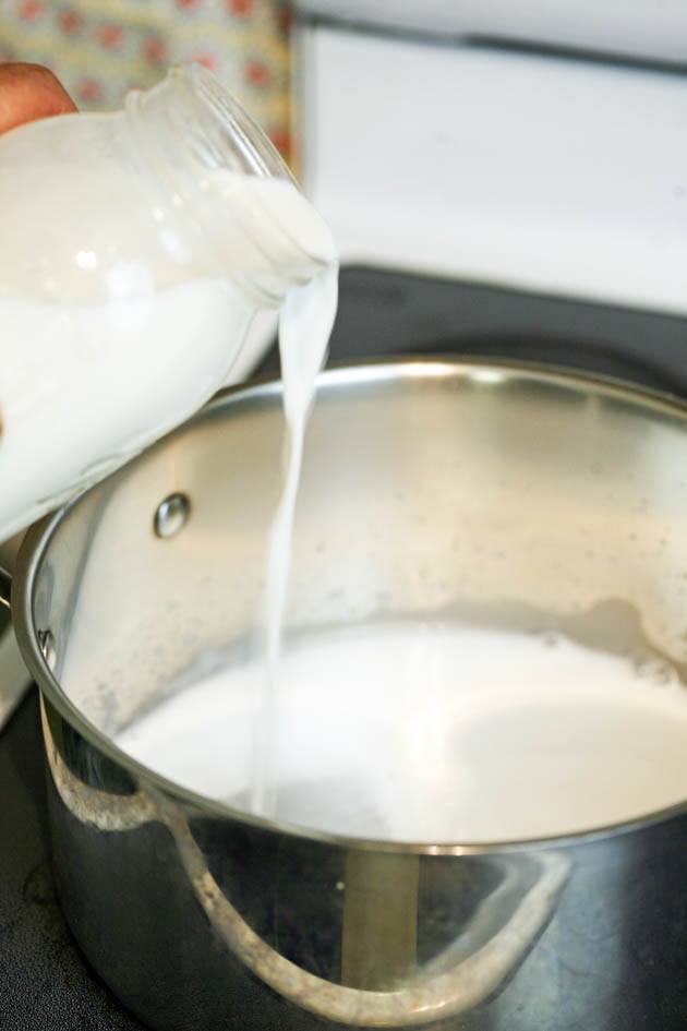 Adding raw milk to the pot.