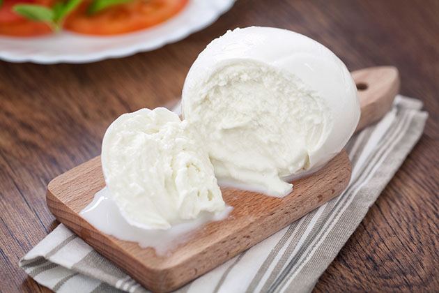 Homemade Mozzarella cheese on a wooden cutting board. 