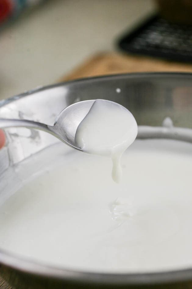 Mixing the yogurt in a bowl to even its texture. 
