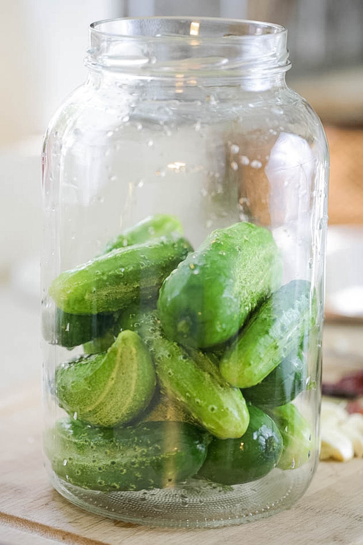 Packing the jar half way with cucumbers.