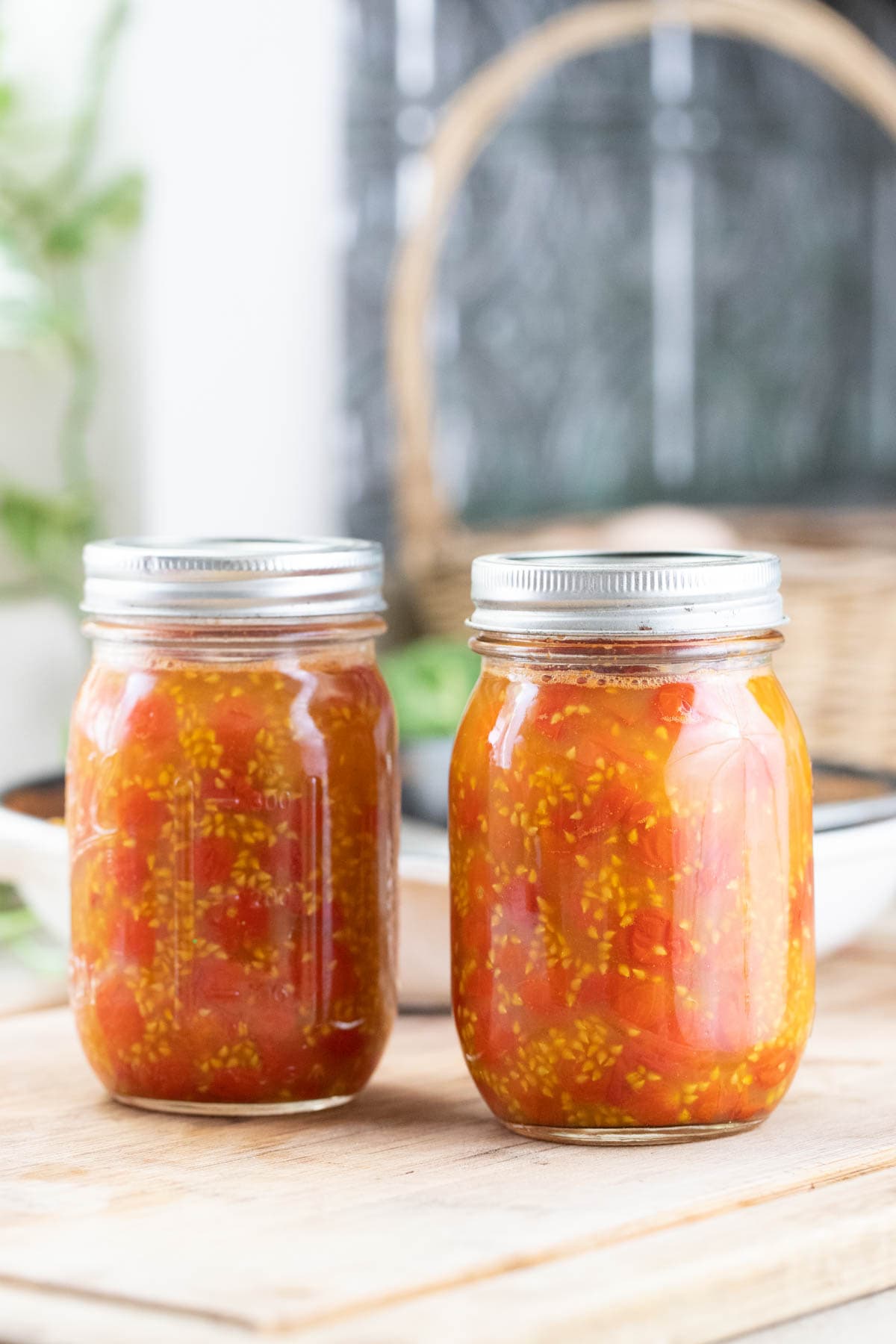 Packing jars with hot pack tomatoes.