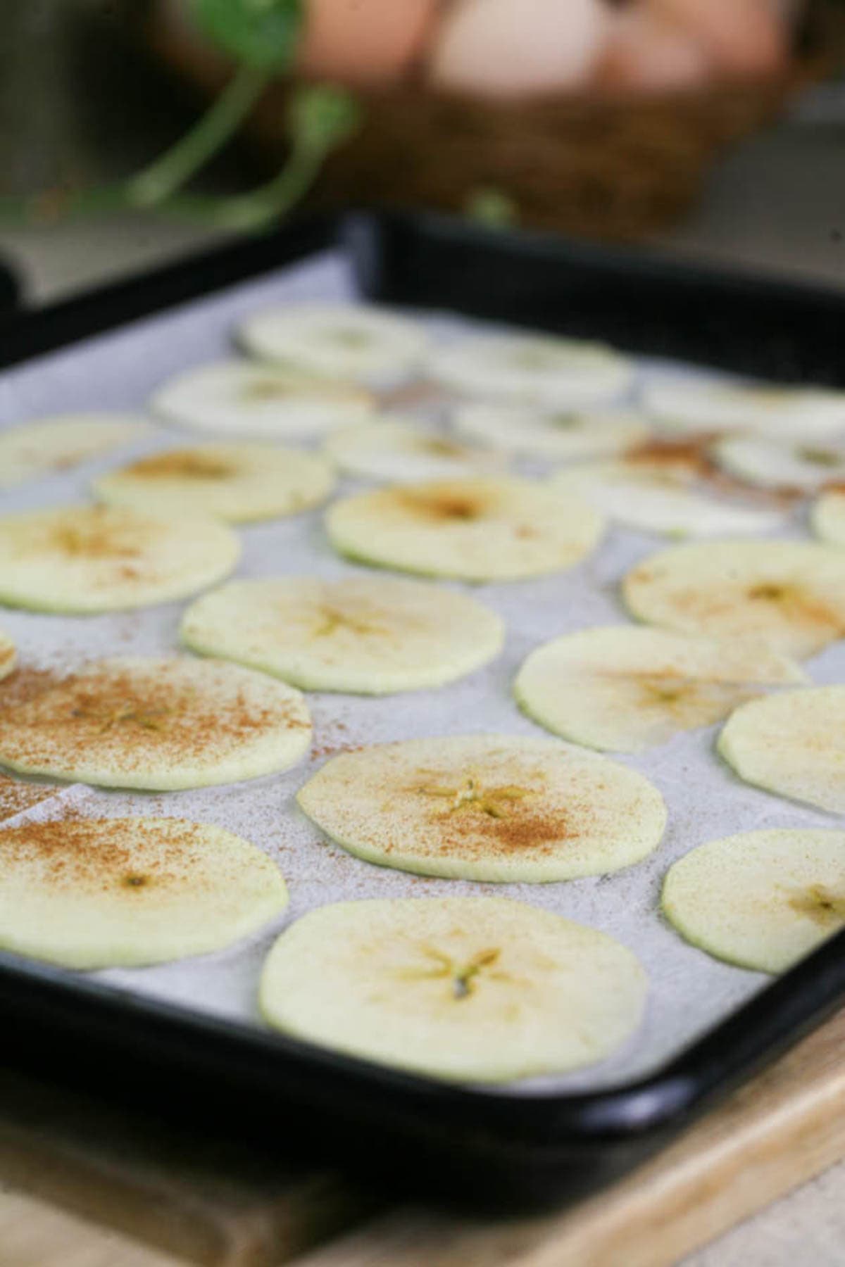 Apple slices set in one layer on a baking sheet. 