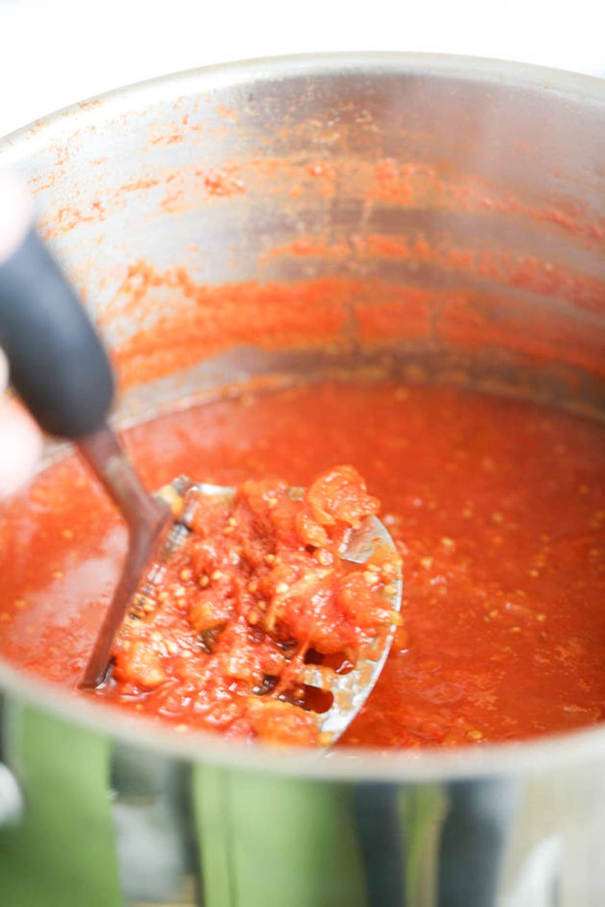 mashing tomatoes before canning.