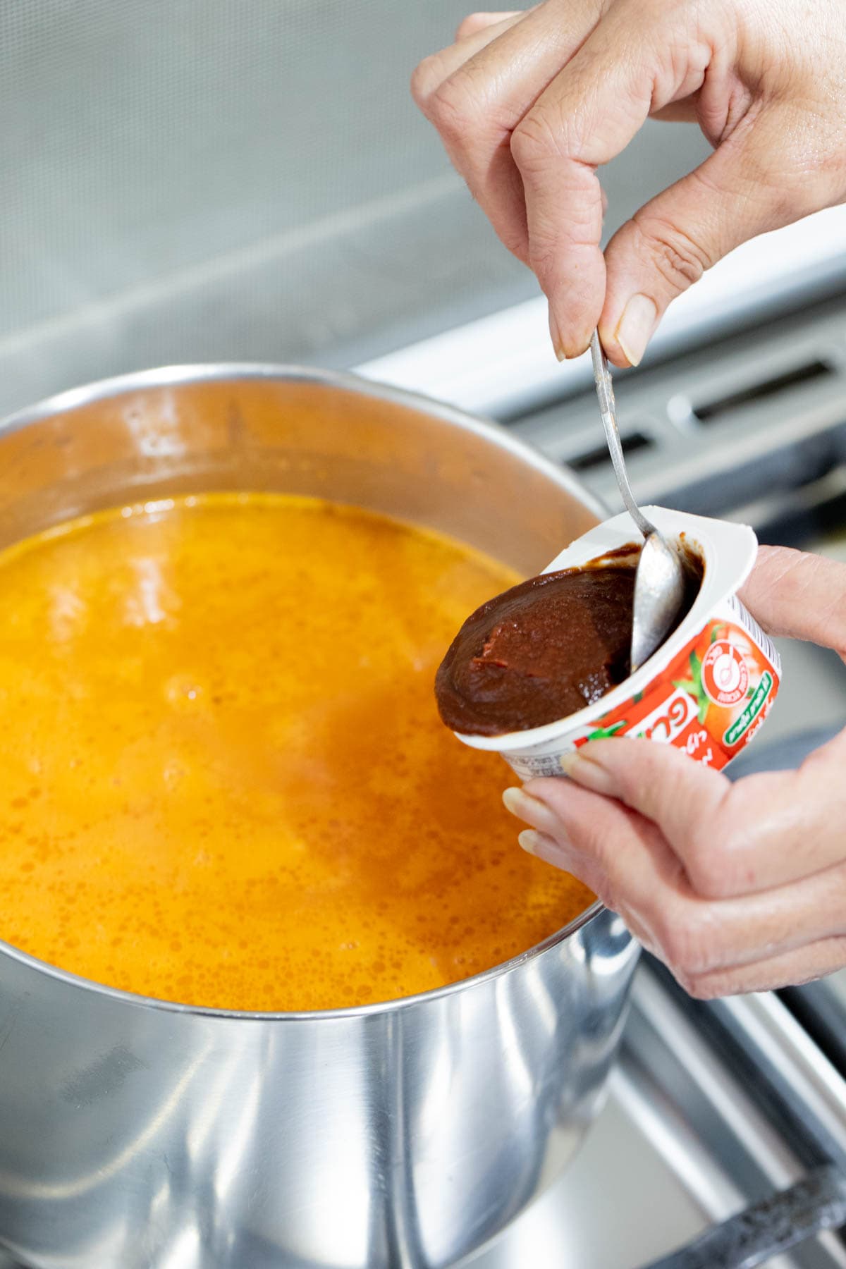 adding tomato paste to the bean soup