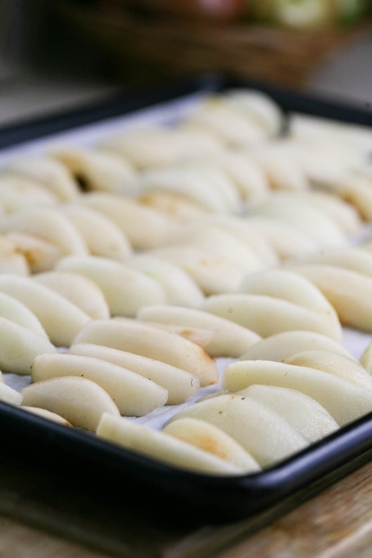 peeled pears set on a baking sheet before freezing
