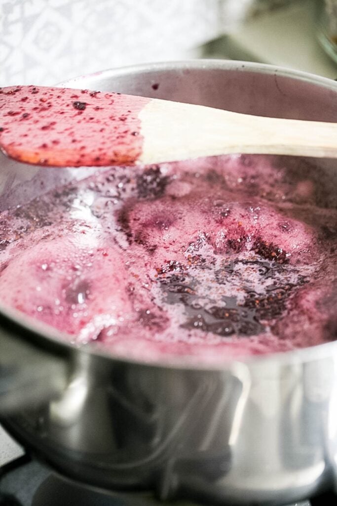 bringing mulberries and sugar to a boil