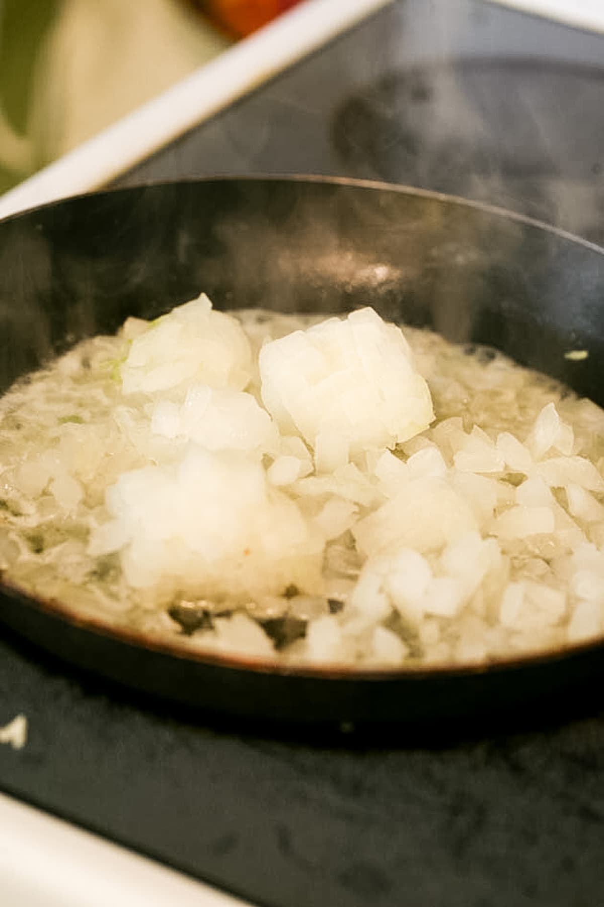 adding diced onions to the hot pan