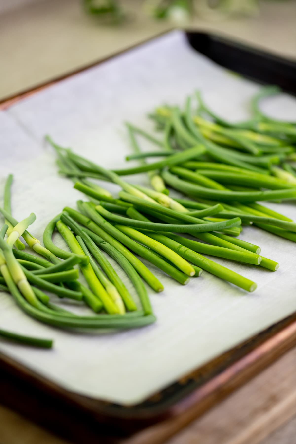 setting the garlic scapes on a baking sheet lined with parchment paper