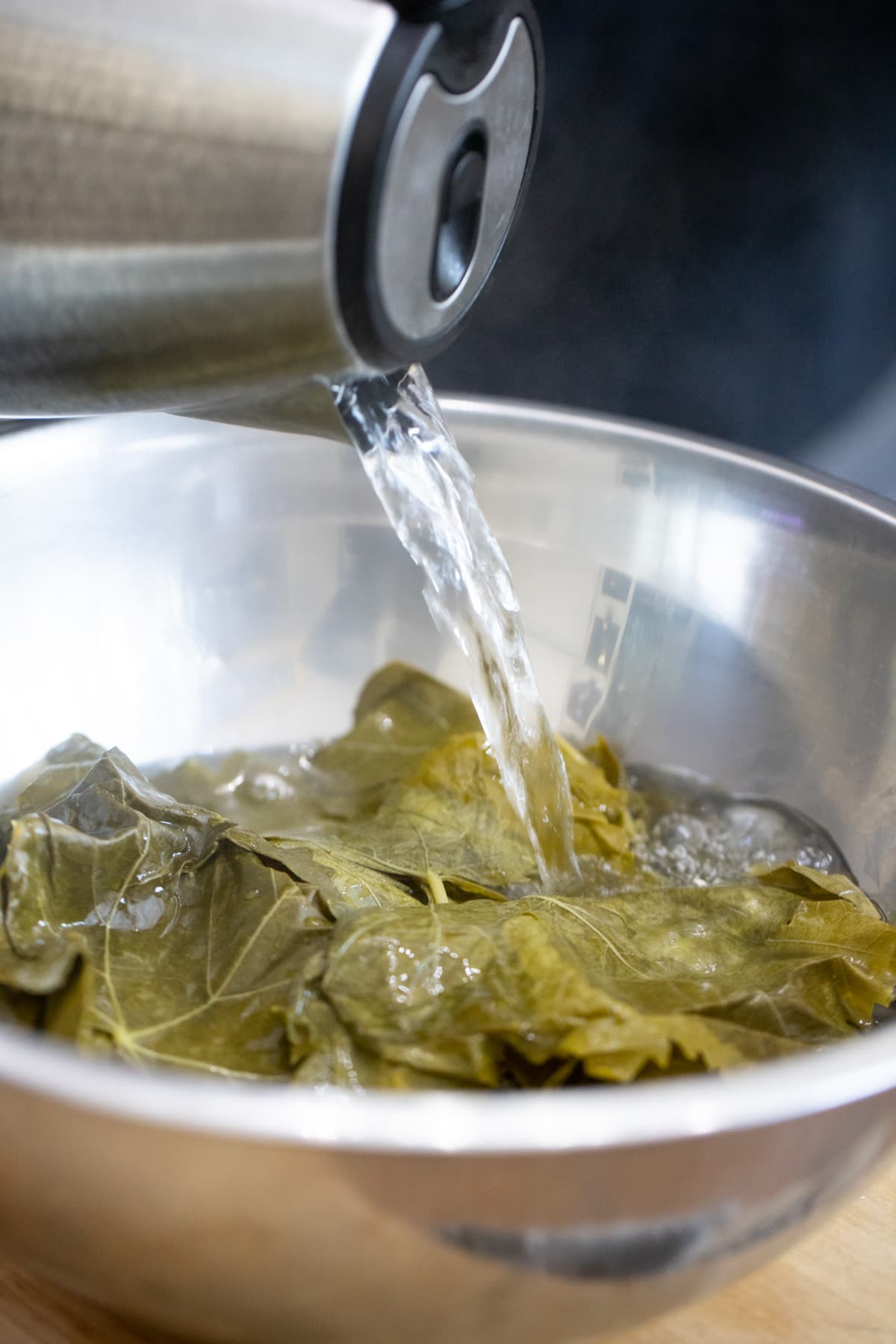 adding boiling water over the grape leaves