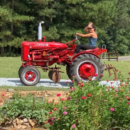 Lee Traister riding a red tractor