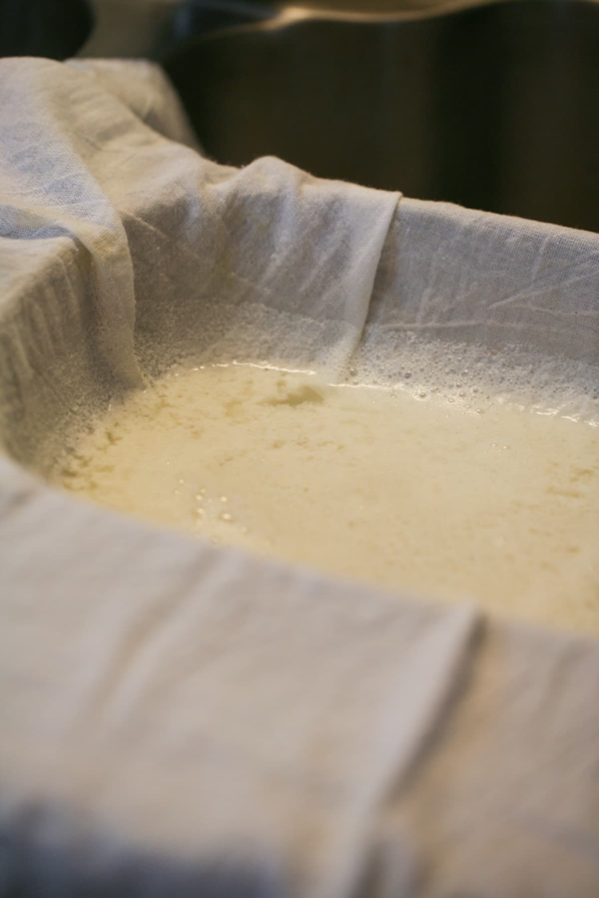 adding the curdled whey to the flour sack