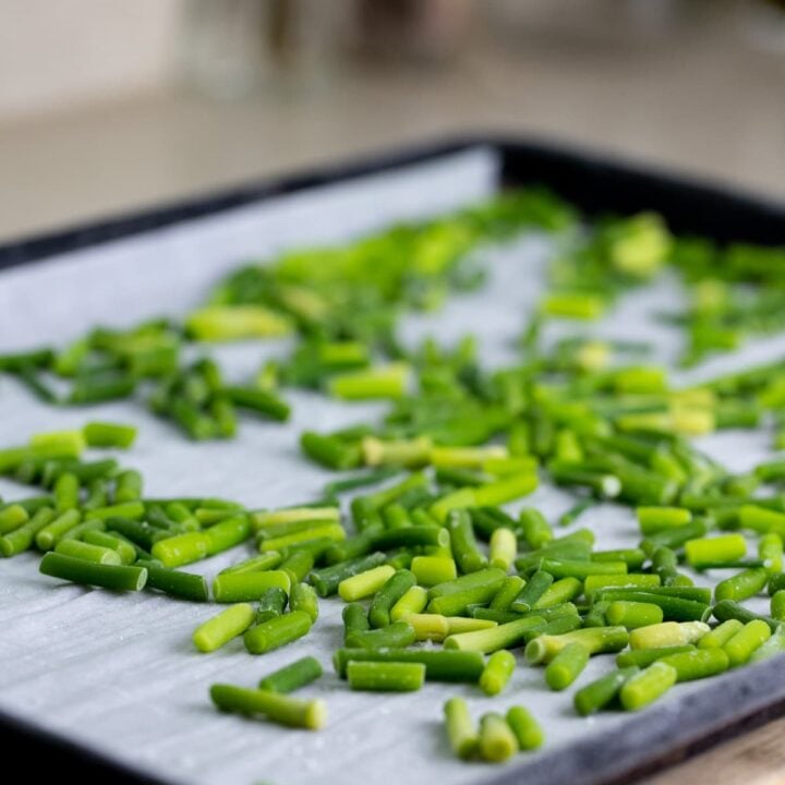 garlic scapes frozen in one layer on a baking sheet