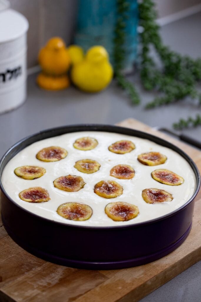 adding more cheese and more figs to fill the pan