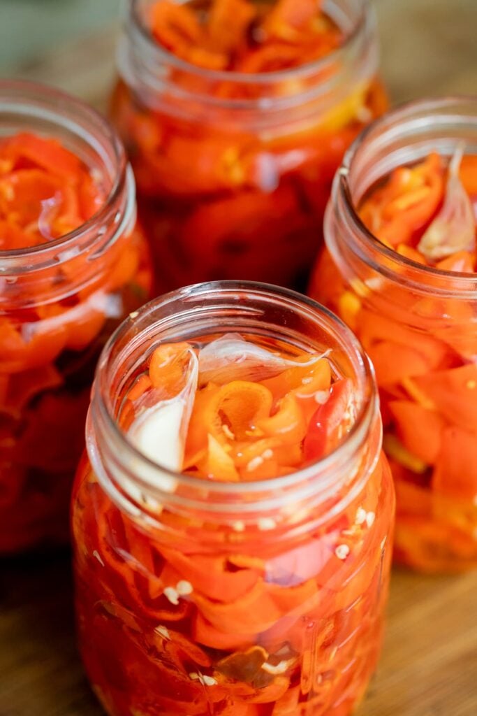 adding pickling brine to the jars of habanero peppers